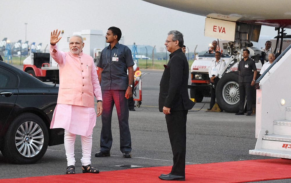 Prime Minister Narendra Modi waves before his departure for the five-day Japan tour, at Palam Airport in New Delhi.