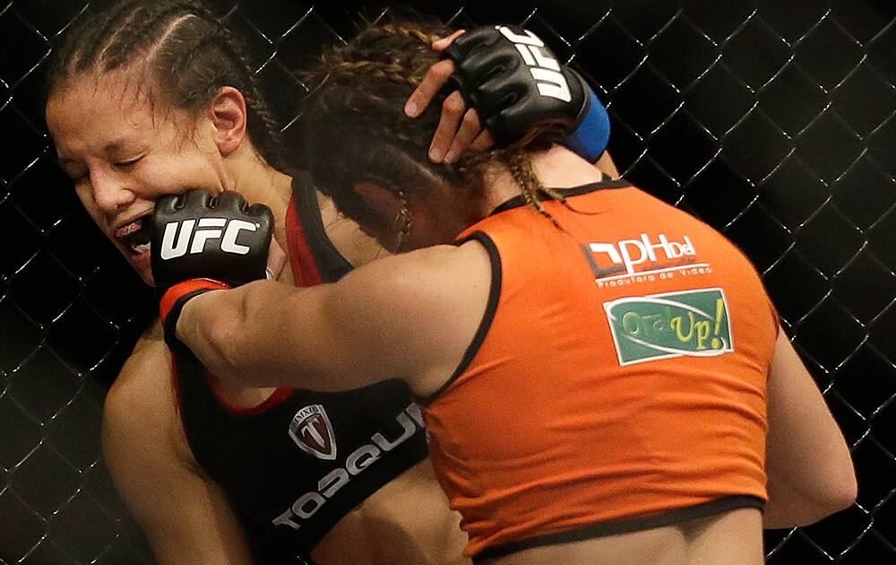 Bethe Correia, right, punches Shayna Baszler during the second round of a women's bantamweight mixed martial arts bout at UFC 177 in Sacramento.