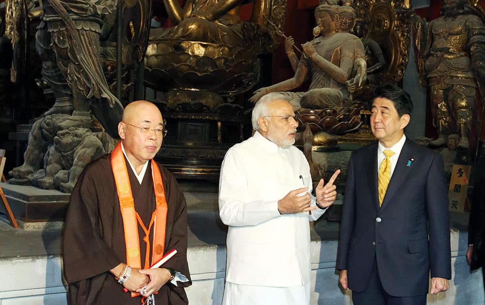 Indian Prime Minister Narendra Modi, center, and his Japanese counterpart Shinzo Abe, right, tour at Toji Temple in Kyoto, western Japan.