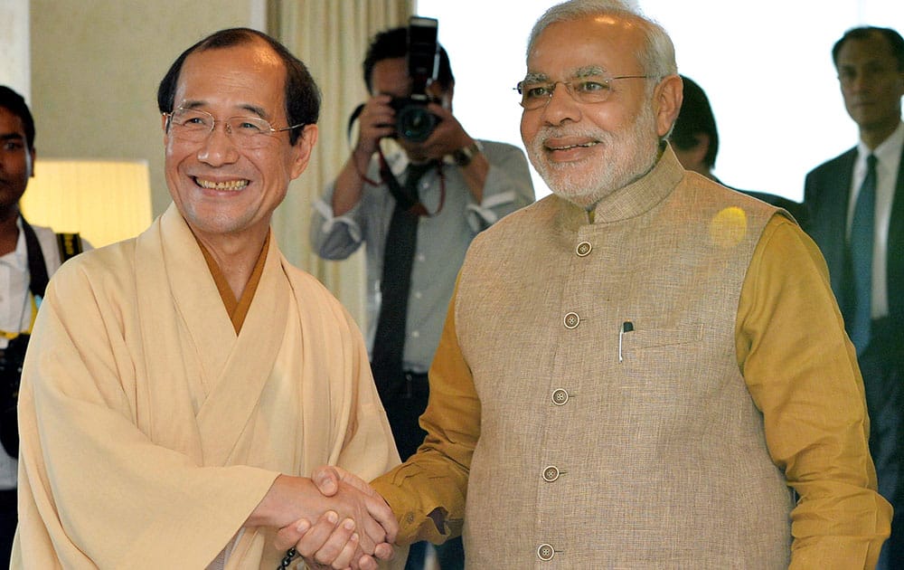 Indian Prime Minister Narendra Modi, right, shakes hands with Kyoto Mayor Daisaku Kadokawa in Kyoto, western Japan.