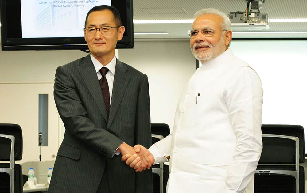Indian Prime Minister Narendra Modi, left, and iPS cell researcher and Nobel Prize laureate, Shinya Yamanaka, pose for photos during Modi's visit at Kyoto University in Kyoto, western Japan.
