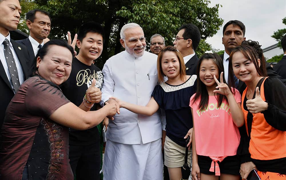 Prime Minister Narendra Modi poses for a photo with tourists during his visit at Golden Pavilion, Buddhist temple in Kyoto Japan.
