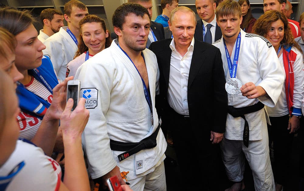 Russian President Vladimir Putin, center right, poses for a photo with athletes while attending the Judo World Cup in the city of Chelyabinsk in Siberia, Russia.