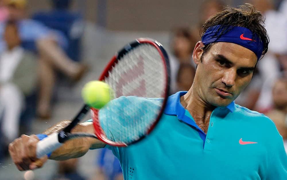 Roger Federer, of Switzerland, returns the ball against Marcel Granollers, of Spain, during the third round of the US Open tennis tournament.