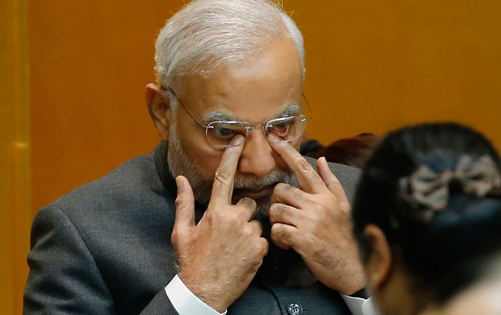 Indian Prime Minister Narendra Modi presses his eyes by fingers during a luncheon hosted by Japan Business Federation in Tokyo.