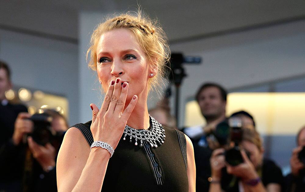 Actress Uma Thurman poses for photographers as she arrives for the screening of Nymphomaniac: Volume I at the 71st edition of the Venice Film Festival.