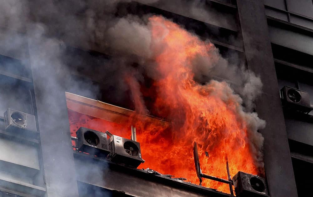 Smoke and flames billowing out of a window after a fire at a building in Kolkata.