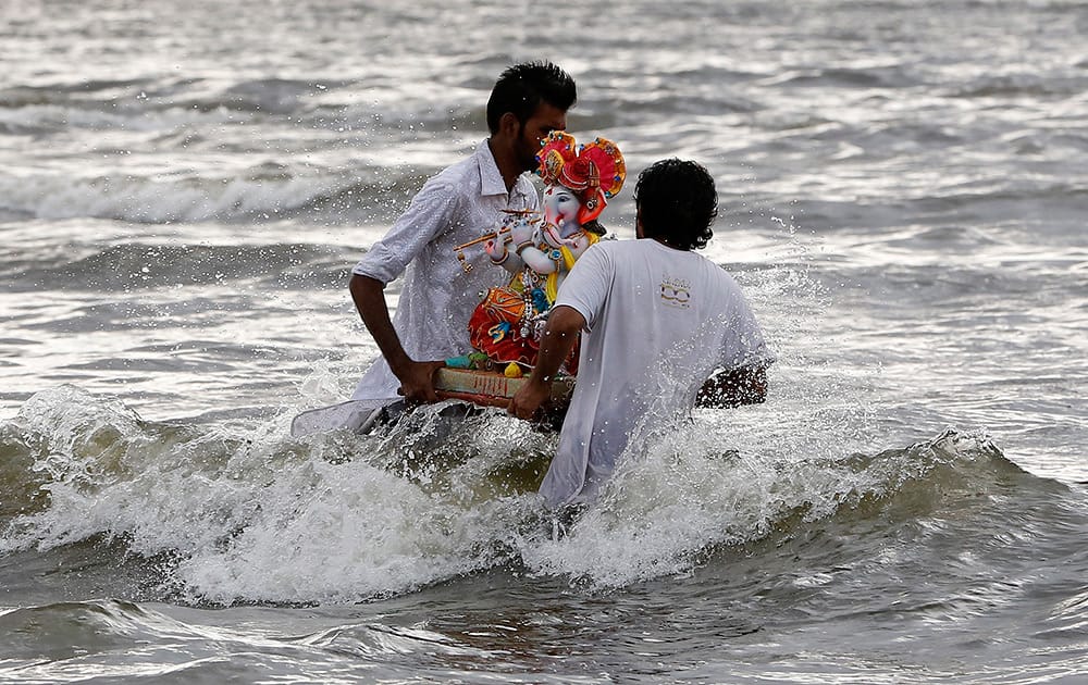 Hindu devotees carry an idol of God Ganesha for immersion in a water body on the second day of the ten-day Ganesh festival in Mumbai.