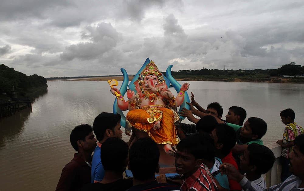 Devotees prepare to immerse an idol of Hindu god Ganesha into the River Kuakhai after worshiping the same during the Ganesh Chaturti festival on the outskirts of Bhubaneswar.