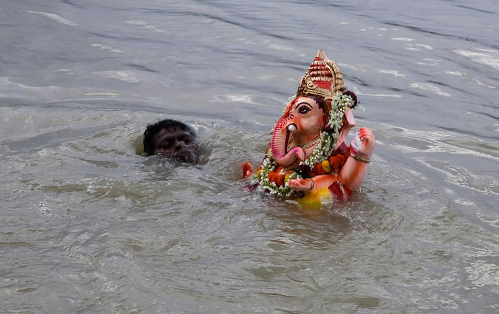A man prepares to immerse an idol of Hindu god Ganesha in the River Ganges after worshiping the same during the Ganesh Chaturti festival in Kolkata.