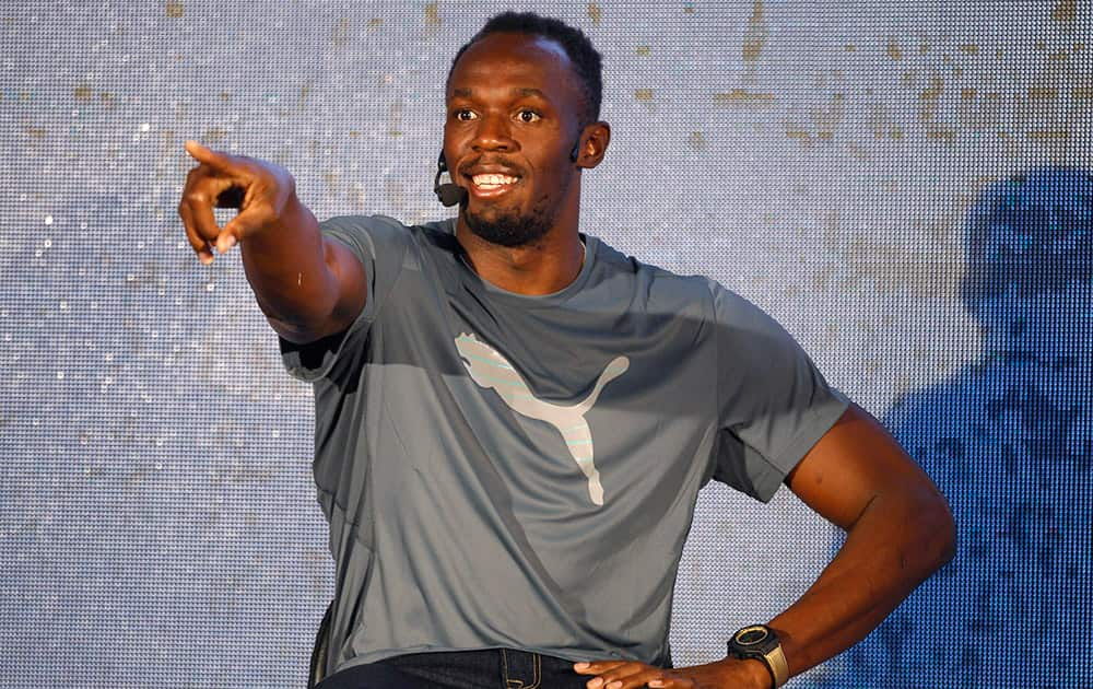 Jamaican sprinter Usain Bolt gestures towards an athlete during an interaction with Indian runners and journalists in Bangalore.