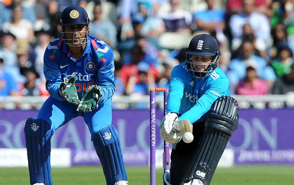 England's Joe Root strikes the ball watched by India's M.S. Dhoni, left, during the fourth One Day International match between England and India at Edgbaston cricket ground, Birmingham.