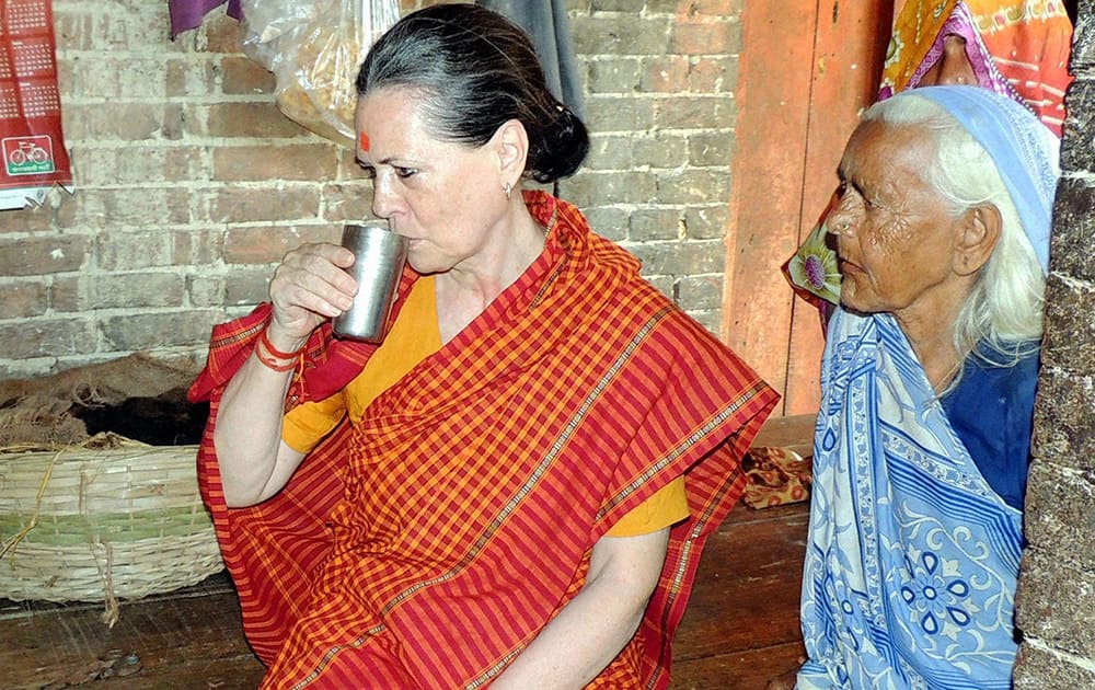 Sonia Gandhi drinks water at a villager's house in Rae Bareli.