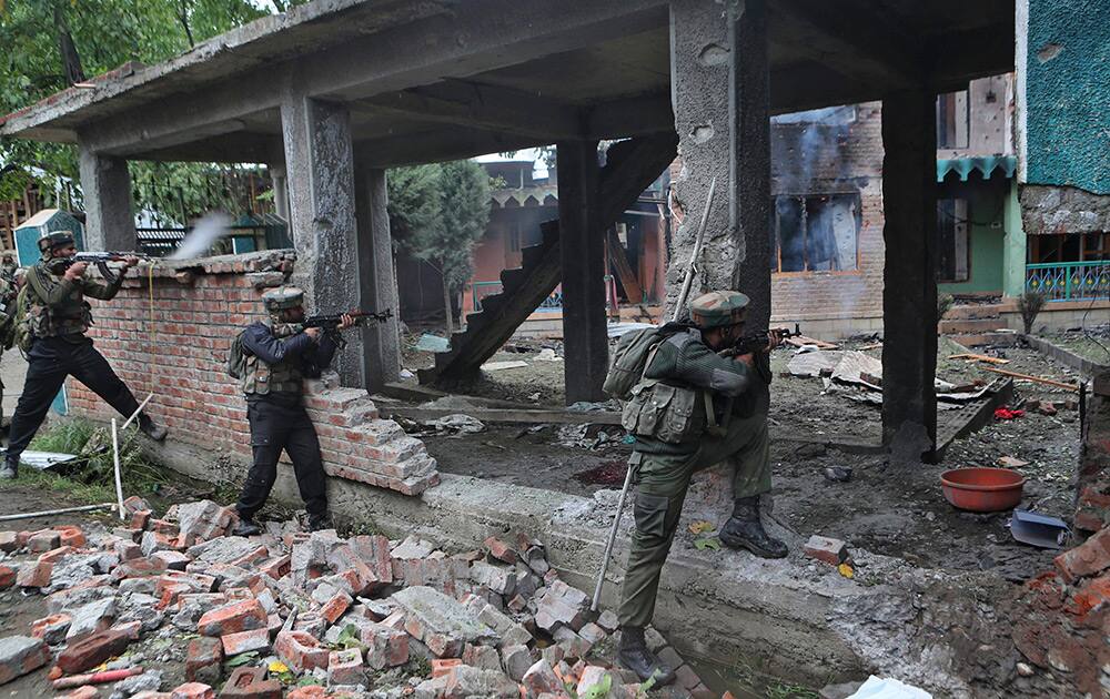 Indian army soldiers fire towards a house where suspected militants are hiding in Rajpora village south of Srinagar.