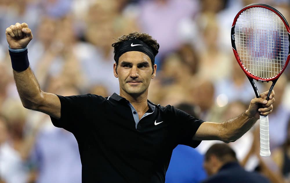 Roger Federer, of Switzerland, raises his arms after defeating Roberto Bautista Agut, of Spain, 6-4, 6-3, 6-2 during the fourth round of the US Open tennis tournament.