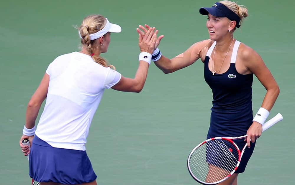 Ekaterina Makarova, of Russia, left, high fives Elena Vesnina, of Russia, during a quarterfinals doubles match against Serena and Venus Williams at the 2014 US Open tennis tournament.