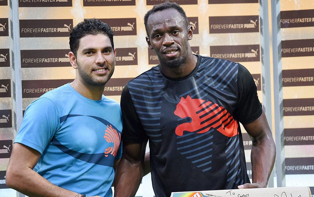 Yuvraj Singh presents a bat signed by him to Olympic Gold Medalist sprinter Usain Bolt in the sidelines of a friendly cricket match in Bengaluru.