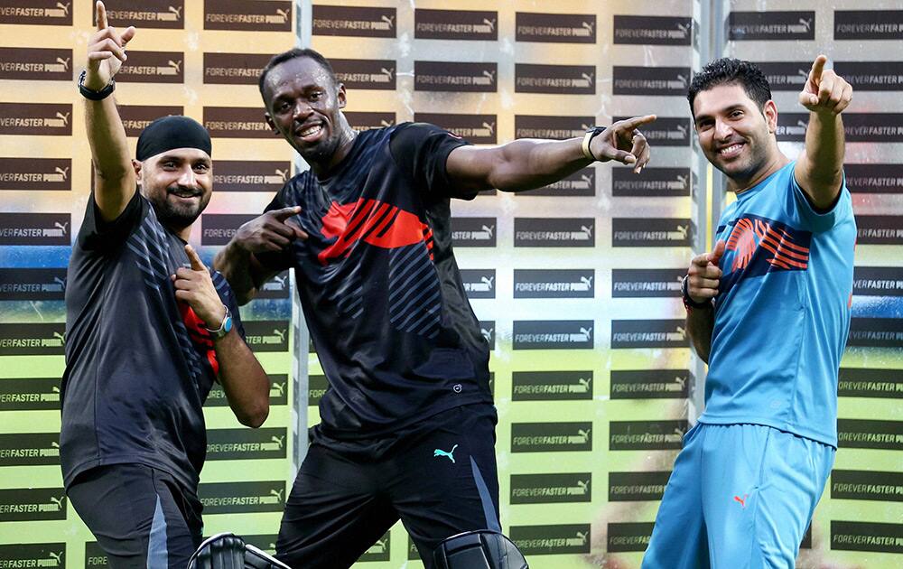 Olympic Gold Medalist sprinter Usain Bolt strikes his trademark pose with cricketer Yuvraj Singh & Harbhajan Singh during a friendly cricket match in Bengaluru.