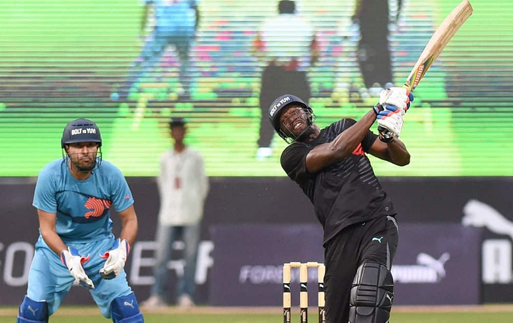 Olympic gold medalist sprinter Usain Bolt plays a shot in a friendly cricket match in Bengaluru.