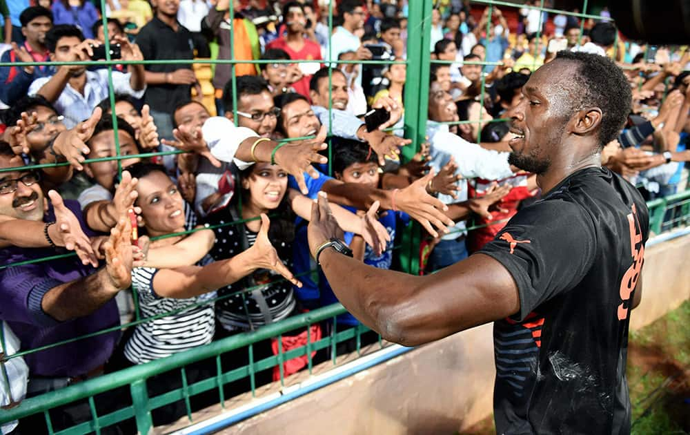 Olympic Gold Medalist sprinter Usain Bolt greets fans during a friendly cricket match in Bengaluru.