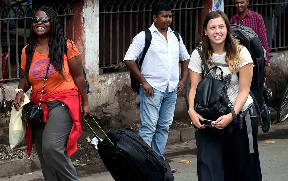Foreign tourists carrying luggage upon their arrival at Howrah station in Kolkata on Wednesday during a taxi strike.