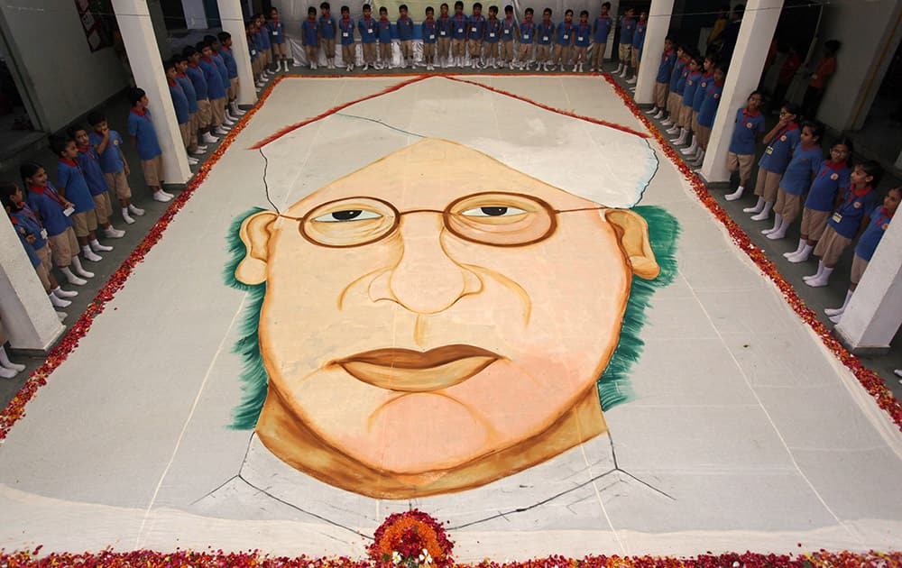 Indian students stand beside a portrait of former Indian President Sarvepalli Radhakrishnan at a school in Ahmedabad.
