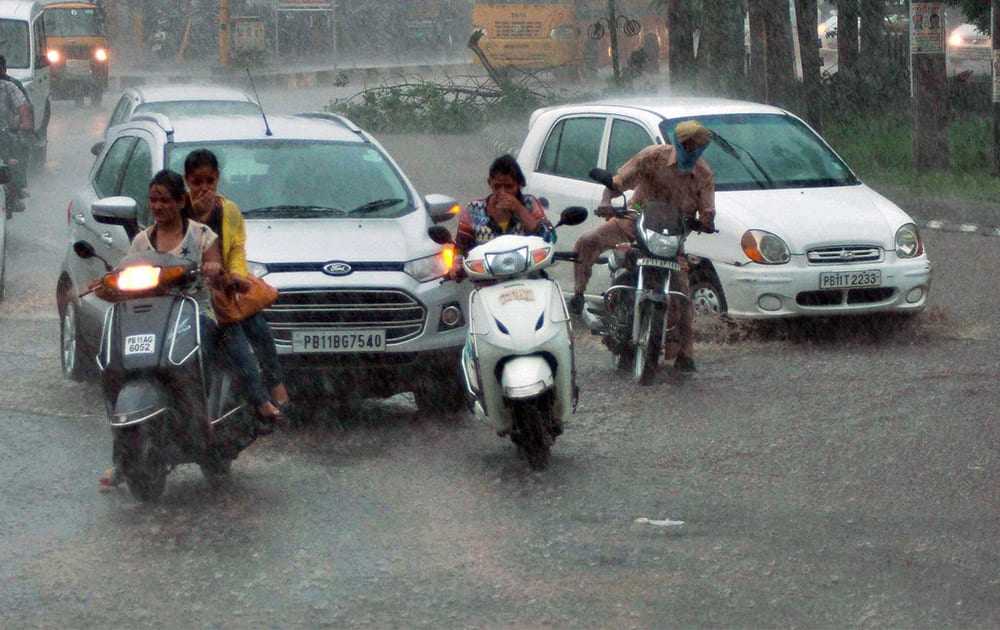 Vehicles plying at during heavy rain in Patiala.