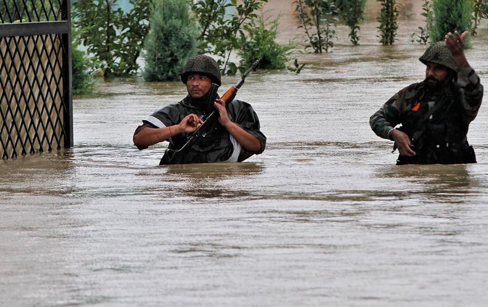 Indian army soldiers walk through a flooded road during a rescue operation in Srinagar.