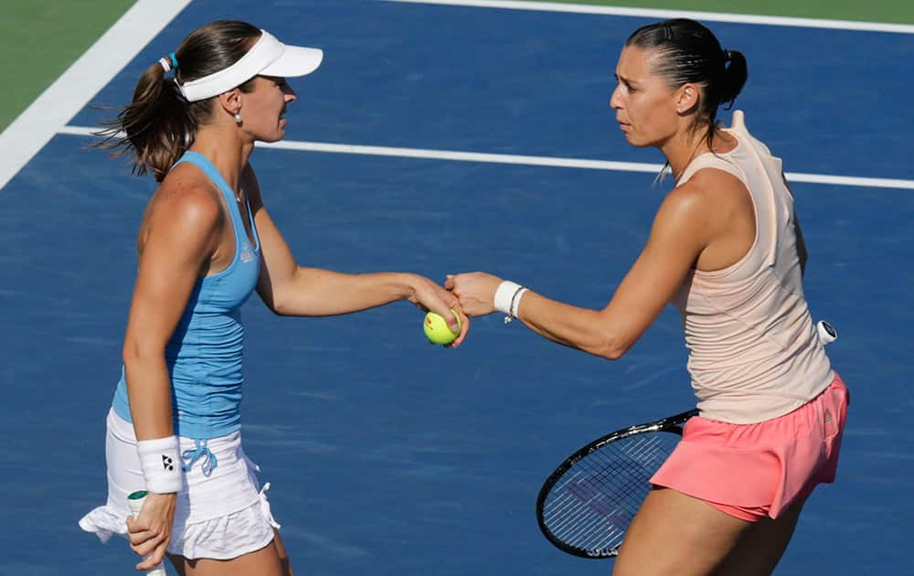 Martina Hingis, left, pumps fists with Flavia Pennetta during a semifinal doubles match against Cara Black and Sania Mirza at the 2014 US Open tennis tournament.