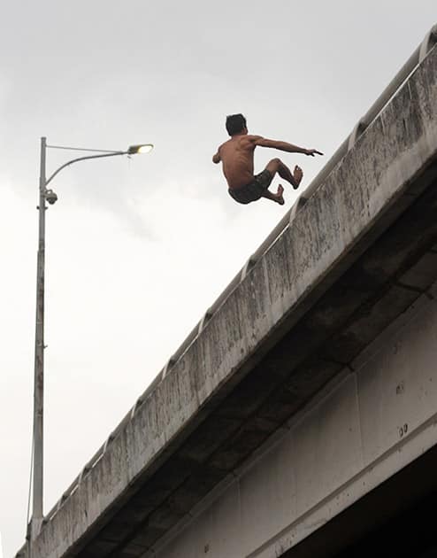 Ruel Adona, 43, jumps from the railing of a highway flyover in a suicide attempt at suburban Quezon city, northeast of Manila, Philippines. Rescuers from the Metropolitan Manila Development Authority tried to rush with a rescue cushion but failed to catch him. A distraught Adona survived the jump and is now recuperating in a hospital.