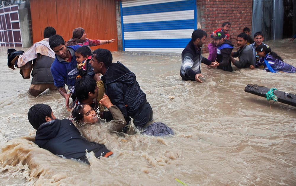 Kashmiri residents wade through floodwaters in Srinagar.