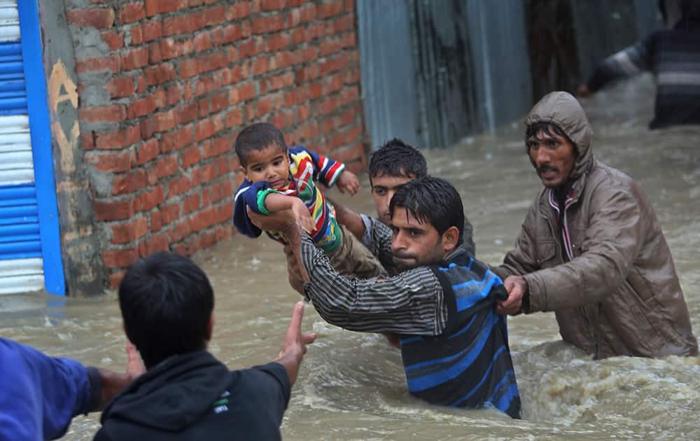 Kashmiri men carry a boy to safety after their neighborhood was flooded in Srinagar.