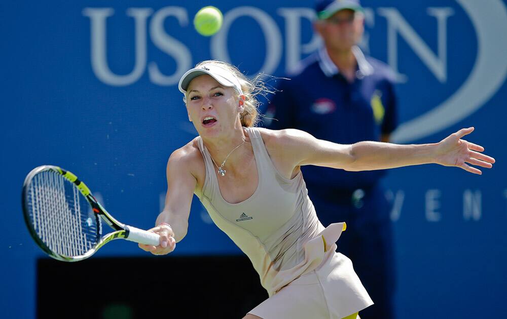 Caroline Wozniacki, of Denmark, returns a shot against Peng Shuai, of China, during the semifinals of the 2014 U.S. Open tennis tournament.