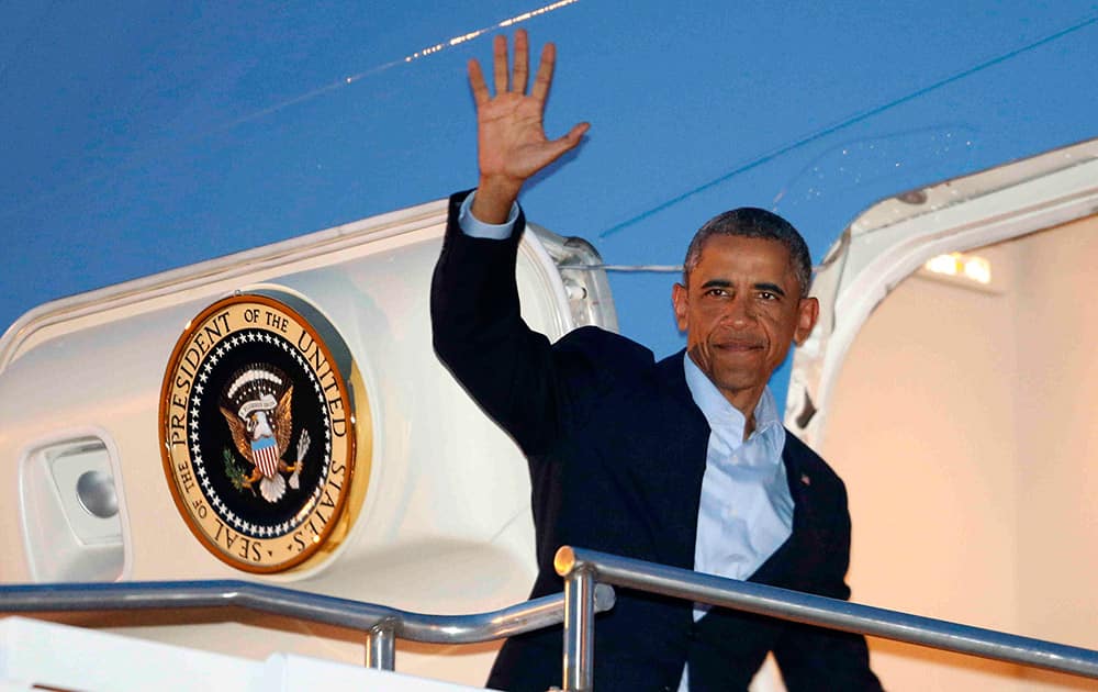 President Barack Obama waves as he boards Air Force One at Royal Air Force Station Fairford, in Gloucestershire, for his return to Washington after attending the NATO summit in Wales.