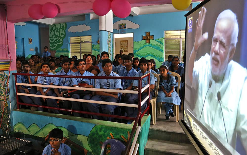 School children and teachers watch a live telecast of Prime Minister Narendra Modi's speech from New Delhi, at their school in Bangalore.