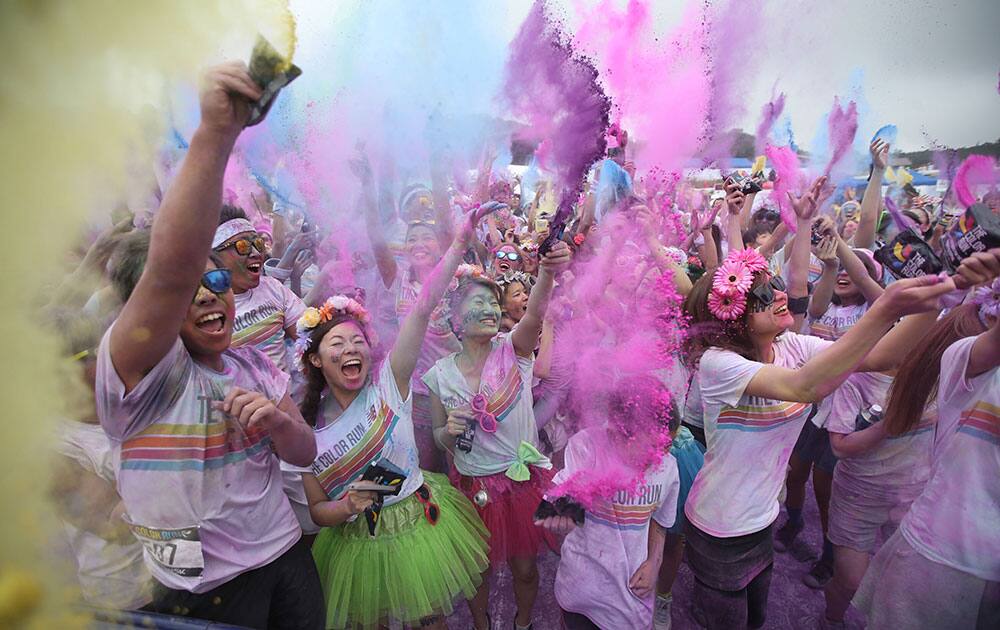 Some of the over 6,000 participants in the Color Run 5 kilometers, throw colored powder and celebrate upon crossing the finish in Susono, at the foot of Mt. Fuji, southwest of Tokyo.
