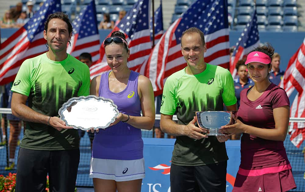 Bruno Soares, second from right, and Sania Mirza, right, pose for photos with the championship trophy alongside runners up Santiago Gonzalez and Abigail Spears after winning the mixed doubles final of the 2014 US Open tennis tournament.