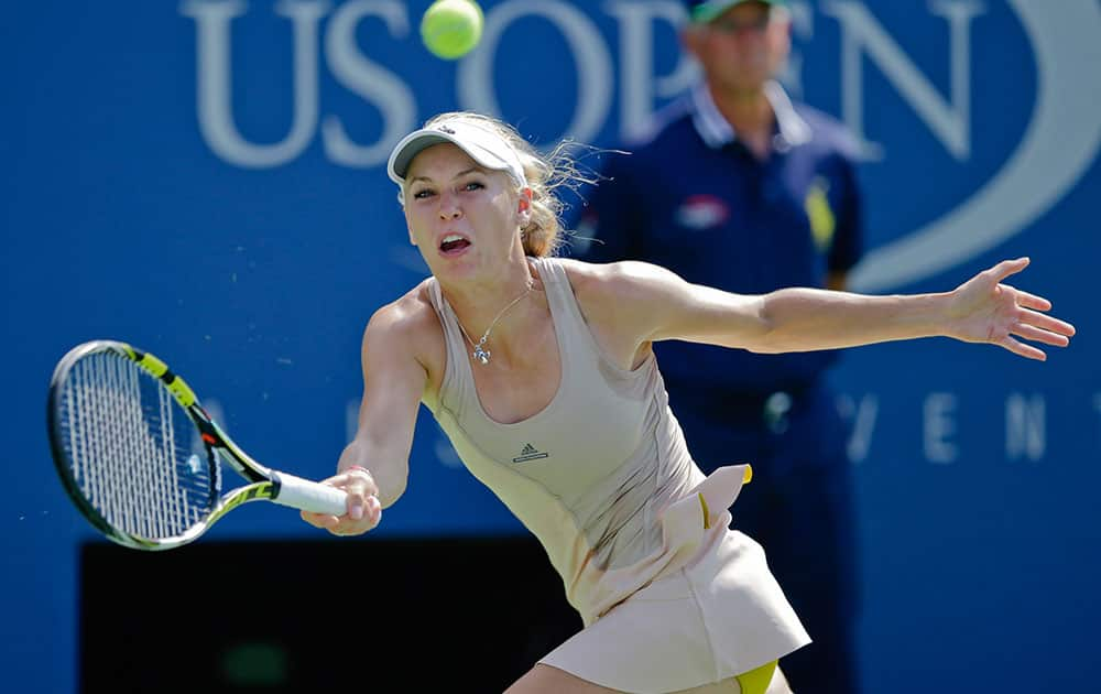 Caroline Wozniacki, of Denmark, returns a shot against Peng Shuai, of China, during the semifinals of the 2014 US Open tennis tournament.