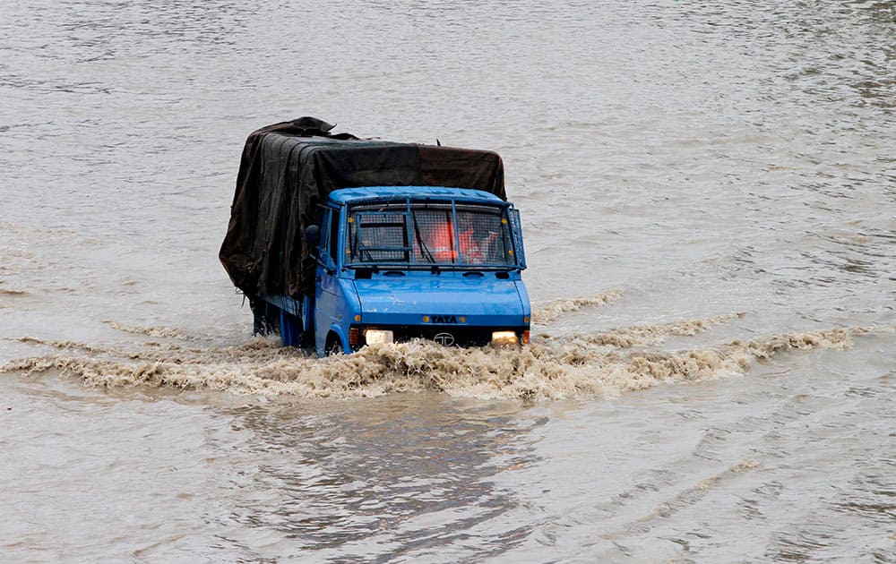 Rescue workers travel in a vehicle past floodwaters in Srinagar.