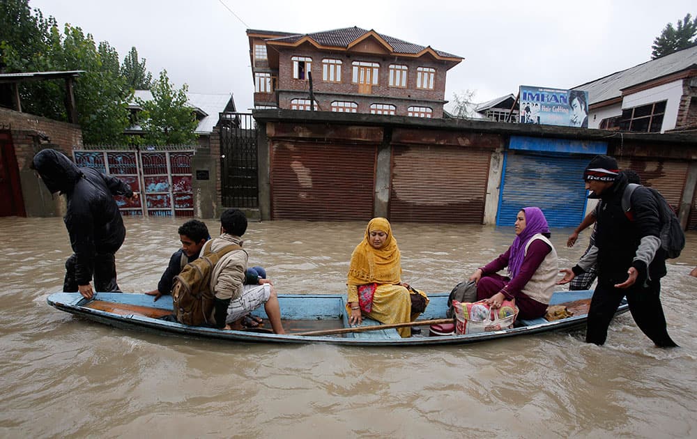 Residents leave a flooded neighborhood on a boat in Srinagar.