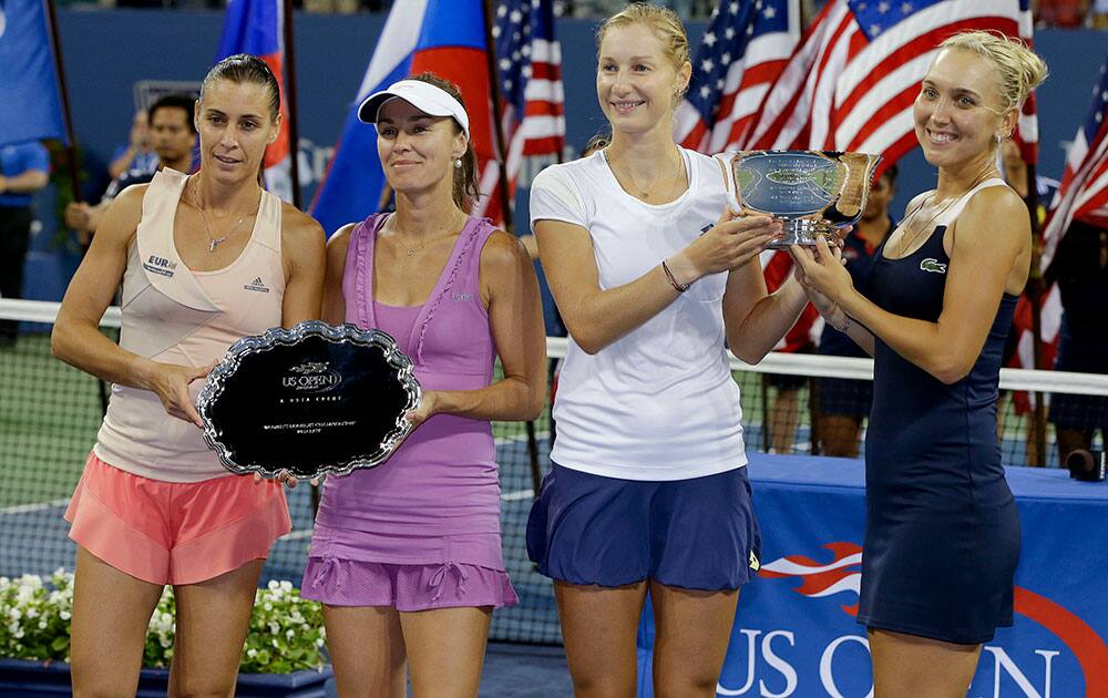 Elena Vesnina, right, and Ekaterina Makarova, of Russia, second from right, pose with the women's doubles championship trophy alongside runners up Flavia Pennetta, of Italy, left and Martina Hingis, of Switzerland, at the 2014 US Open tennis tournament.