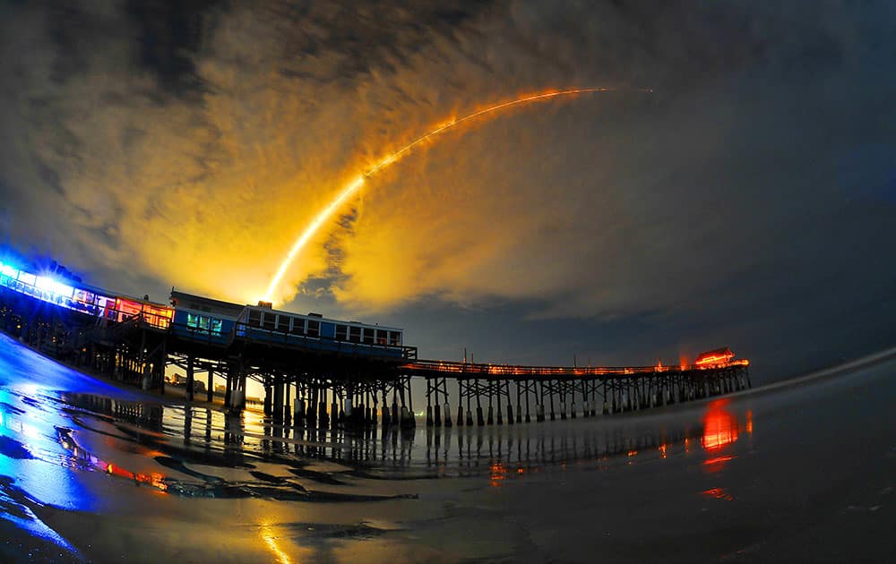 A Space X Falcon 9 rocket carrying the AsiaSat 6 mission for the United State Air Force turn's night into day during a early Sunday morning launch Sept. 7, 2014 from the Cape Canaveral Air Force Station in foreground the Cocoa Beach Pier.