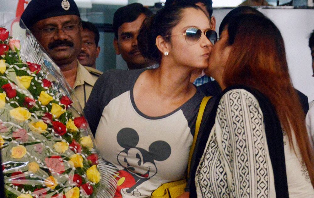 Sania Mirza being received by her mother Nasima Mirza on her arrival at Shamshabad Airport after winning US Open mixed doubles title, on Sunday.