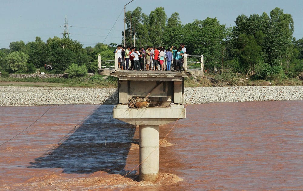 VIEW OF A WASHED AWAY PORTION OF A BRIDGE BY FLOODWATER AT PHALIAN MANDAL IN JAMMU.