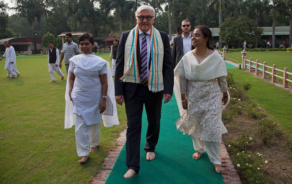 German Foreign Minister Frank-Walter Steinmeier, center, walks after paying tribute at the spot where Mahatama Gandhi was assassinated in New Delhi.