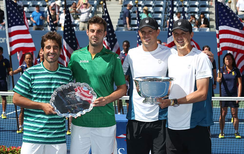 Marc Lopez, left, and Marcel Granollers, of Spain, second from left, pose with Bob, second from right, and Mike Bryan after the Bryan's won the men's doubles championship match of the 2014 US Open tennis tournament.