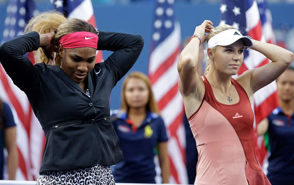 Serena Williams, left, and Caroline Wozniacki, of Denmark, wait for the start of the trophy ceremony after Williams defeated Wozniacki in the championship match of the 2014 US Open tennis tournament.