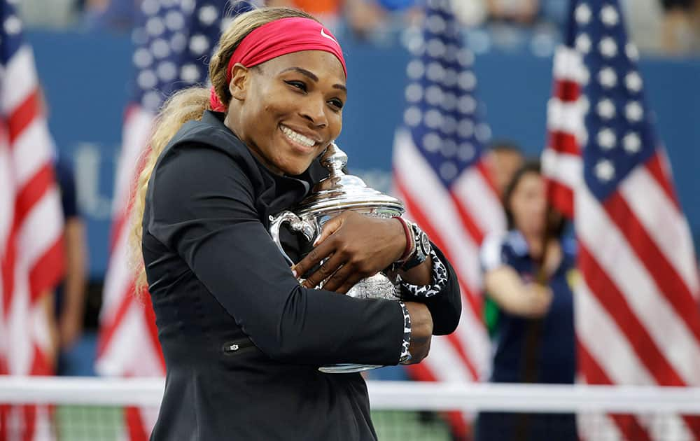 Serena Williams, of the United States, hugs the championship trophy after defeating Caroline Wozniacki, of Denmark, during the championship match of the 2014 US Open tennis tournament.