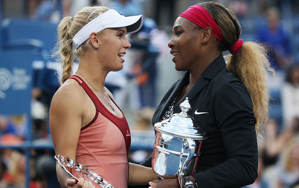 Caroline Wozniacki, of Denmark, left, talks with Serena Williams, of the United States, after Williams won the championship match of the 2014 US Open tennis tournament