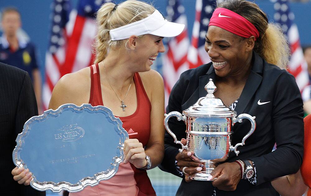 Caroline Wozniacki, of Denmark, left, and Serena Williams, of the United States, pose for photos after Williams defeated Wozniacki in the championship match of the 2014 US Open tennis tournament.